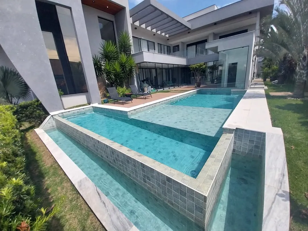 Piscina longa de casa moderna com água azul tratada